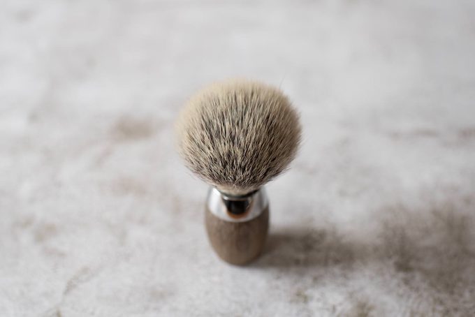 Close-up overhead view of a badger hair shaving brush with a wooden handle