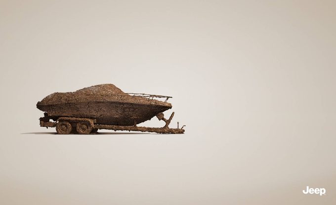 Jeep print ad showing a speedboat on a trailer completely encrusted in dried mud, implying the Jeep towing it went off-road